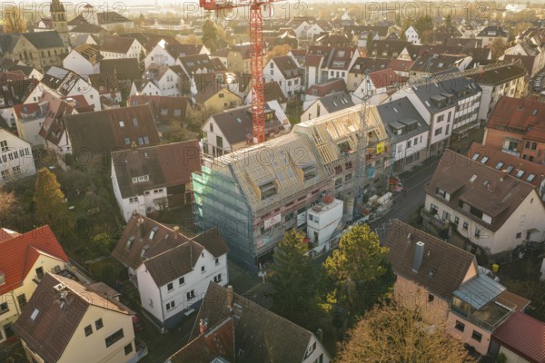 Aerial view of an urban residential area with a visible construction site and a crane, carpentry,