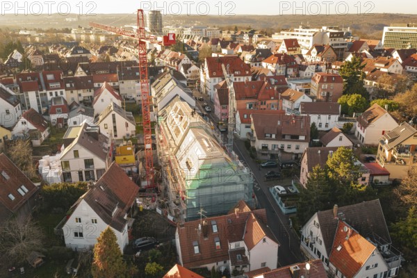 View of a city with a construction site in a residential area and surrounding countryside,