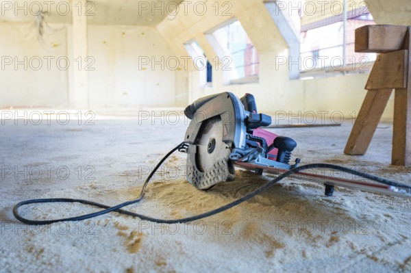 Interior of a construction site with a saw on the ground, carpentry, renovation, roof extension,