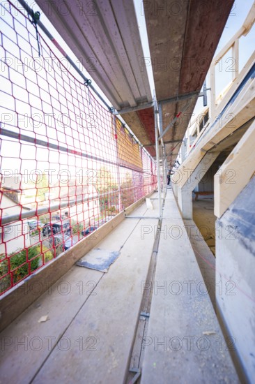 Long scaffolding with red nets, wooden elements and views of construction, carpentry, renovation,