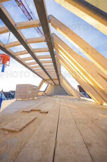 A wooden roof truss with an open sky above. Construction work is in progress, carpentry