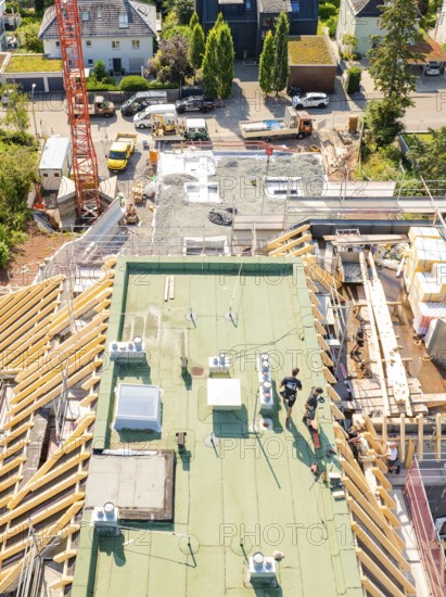 View of the upper construction site with workers and building materials, surrounded by urban