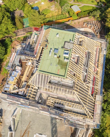 Bird's eye view of a building under construction in a green city scene, carpentry construction