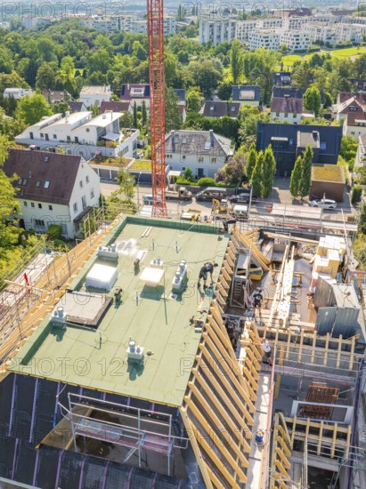 Top view of a building with a crane in an urban environment with lots of greenery, carpentry