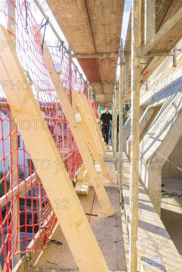 Close area of scaffolding with red safety nets and wooden struts, carpentry construction, roof
