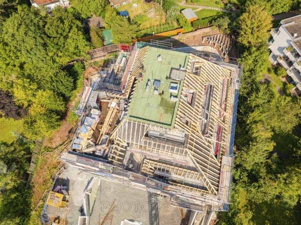 Bird's eye view of a building with roof structure, surrounded by green landscape, carpentry