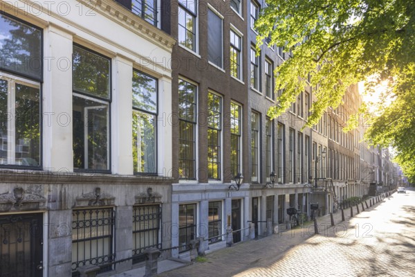 Holland, Amsterdam canals with boats, scenic bridges and historic city center, UNESCO World