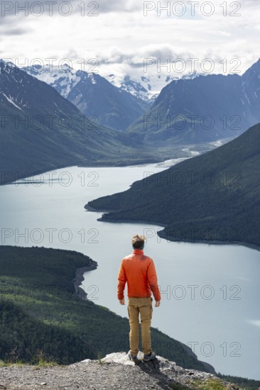 Mountaineer enjoys views of blue lake and mountains on Twin Peaks Trail, Eklutna Lake, Chugach