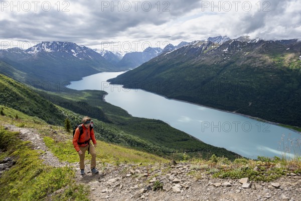 Climbers on a hiking trail, view of blue lake and mountains on Twin Peaks Trail, Eklutna Lake,
