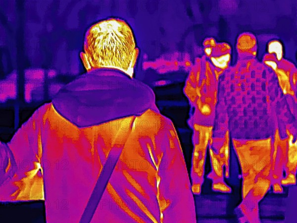 Thermal image or thermography, symbolic photo, interpolated. People traveling in urban areas.