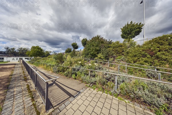 Access to Europe Bridge, park, wooden ramp, stainless steel railing, trees, flower bed, plants,