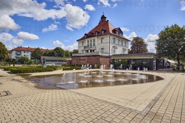 Villa Schmidt restaurant, park, fountain, hedge, lawn, paths, trees, blue partly cloudy sky,