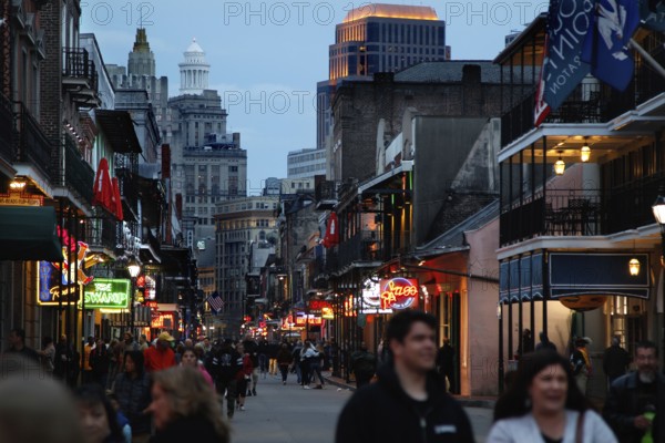 Evening atmosphere on Bourbon Street with illuminated shops and people on the street, New Orleans,
