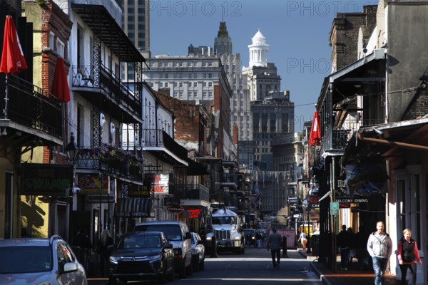 Bustling Bourbon Street in the French Quarter with colonial architecture and pedestrians, New