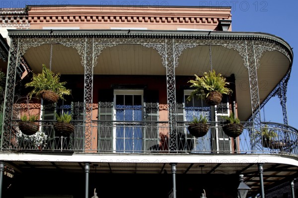 Colonial balcony with decorated ironwork and hanging plants in the French Quarter, New Orleans,
