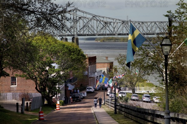 Street view in Natchez with bridge in background and flags along the road, Natchez, Mississippi,