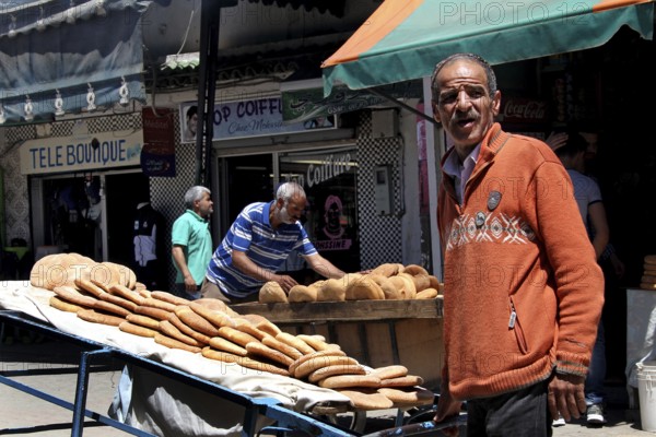 A bread seller presents his goods on the lively Place Mohammed VI in Moulay Idris, Moulay Idris,
