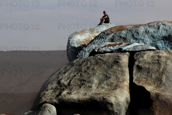 Person on the blue stones of artist Jean Verame with a wide view in Tafraoute, Tafraoute,