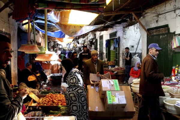 Bustling vegetable market with sellers and customers in a busy market alley, Tetouan, Medina,