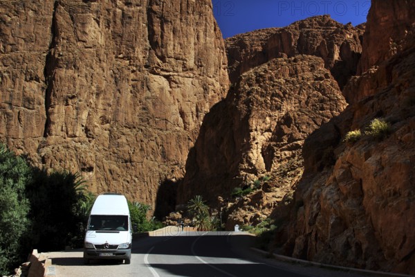 A white transporter drives through the impressive rocks of Todra Gorge, Todra, Gorge