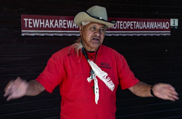 A Maori guide named Philipp explains Maori culture in a red and black outfit, Rotorua, Bay of