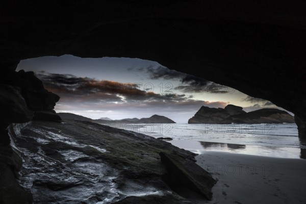 Dramatic coastal scene at Wharariki Beach with a view of the ocean from a cave, Wharariki Beach,