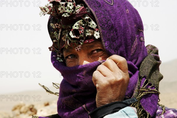Nomad covered with purple cloth looking intensely at the camera, Midelt, null, Morocco