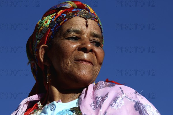 Woman wearing colorful traditional clothing and headdress at the Rose Festival in El Kelâa m'Gouna,