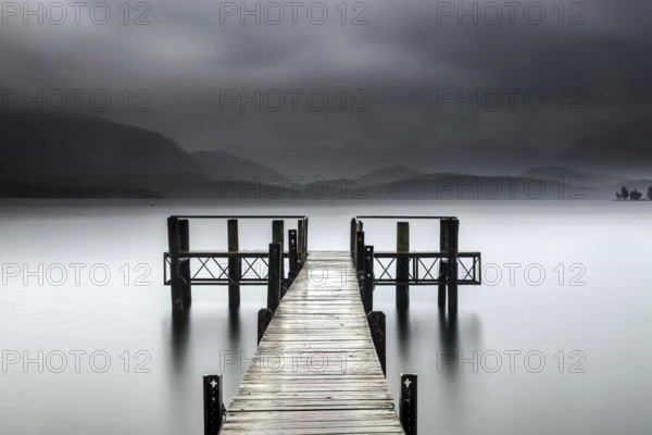 Wooden walkway leads into foggy Lake Te Anau, surrounded by mystical atmosphere, Te Anau,