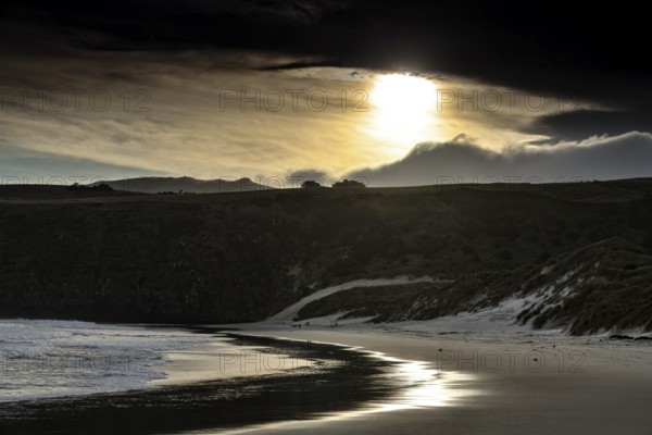 Dramatic evening mood on Sandfly Bay beach under cloudy sky, zero