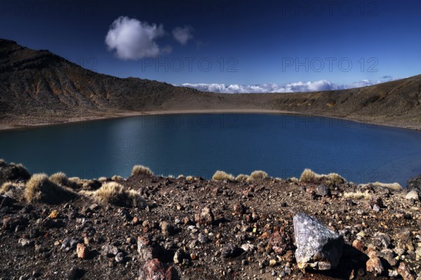 Tranquil Blue Lake in rough crater terrain against clear skies, Tongariro National Park, New