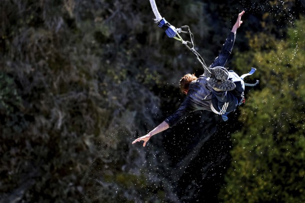 Person in a spread flight position bungee jumping over the countryside, Queenstown, Kawarau Bridge,