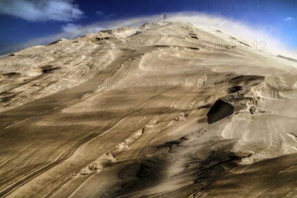 Dramatic Te Paki sand dune in sandstorm under blue sky, Ninety Mile Beach, Te Paki, New Zealand