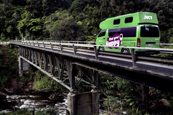 A Jucy camper crosses a bridge across the Tangarakau River on the Forgotten World Highway,