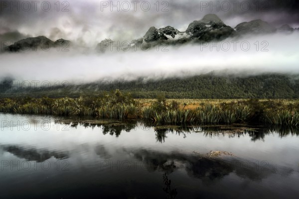 Mountain landscape with dramatic sky is clearly reflected in the calm lake, Mirror Lakes, New