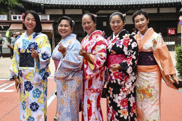 Group of woman wearing colorful kimonos against a traditional backdrop in Tokyo, Tokyo, Asakusa,