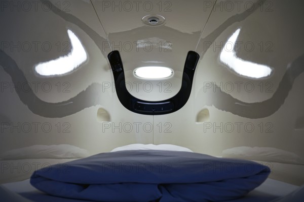 Interior of a capsule hotel sleeping capsule, futuristic design with blue pillow, Tokyo, zero,