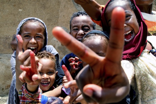 Happy children in Harar smile and show the peace sign, Harar, Oromia, Ethiopia