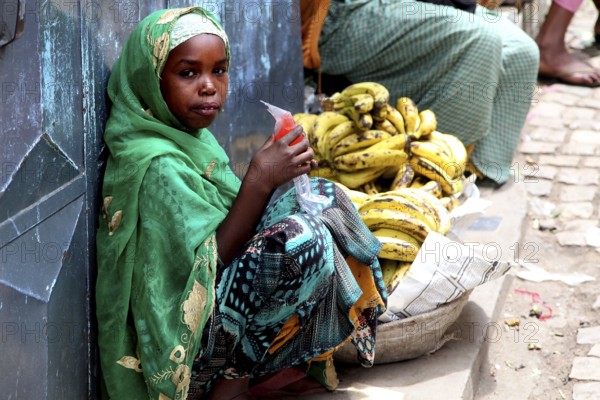 Child banana saleswoman wearing traditional clothes in the old town of Harar, Harar, null