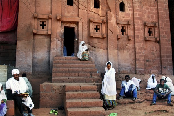 People wearing traditional dress in front of the rock church of Bete Abba Libanos in Lalibela,