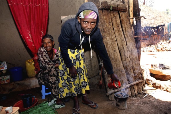 Two woman having a traditional coffee ceremony surrounded by warmth and warmth, Lalibela, Amhara,