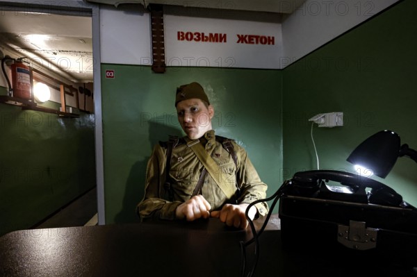 A person in military uniform sits in an atmospherically lit bunker in Plokstine, Plokštine, Telšiai