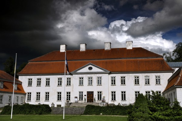 Large historic manor house with dramatic cloudy sky, Suuremäisa, Hiiumaa, Estonia