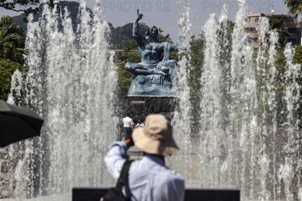 Urakami Peace Park with spray fountain and peace statue, visitors in the foreground, Nagasaki,