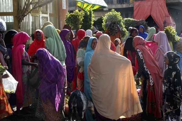 People wearing colorful robes at a busy market, Awaday, Ethiopia