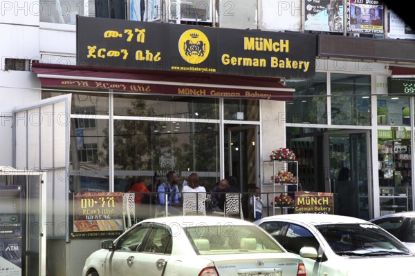 Modern German cafe in an urban setting in Addis Ababa, with cars in the foreground, Addis Ababa,