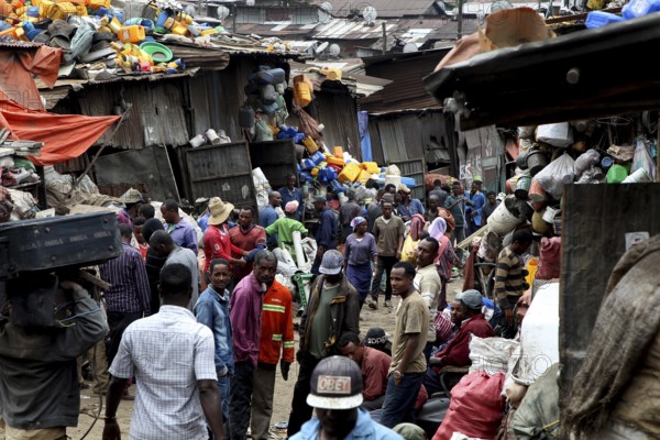 Large crowds of people on the busy Mercato in Addis Ababa, surrounded by colorful fabrics, Addis