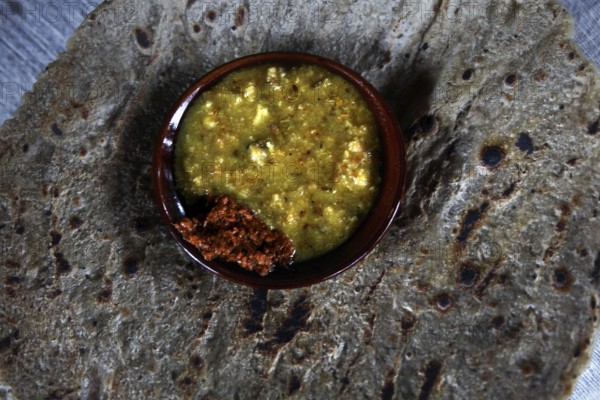 Ensete bread patties with a bowl of yellow sauce in Dorze village, Dorze village, Ethiopia