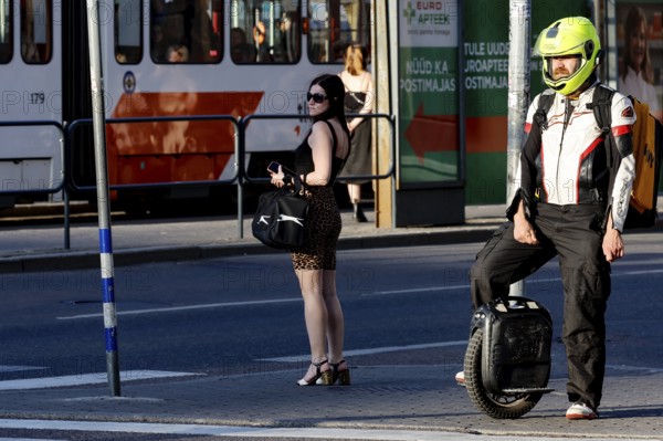 Person on electric scooter with helmet waiting at traffic lights on the road, Tallinn, South Alinn,