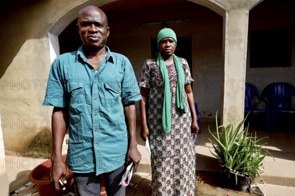 A man and a woman stand in front of their house, radiating strength together, Korhogo, CI, West